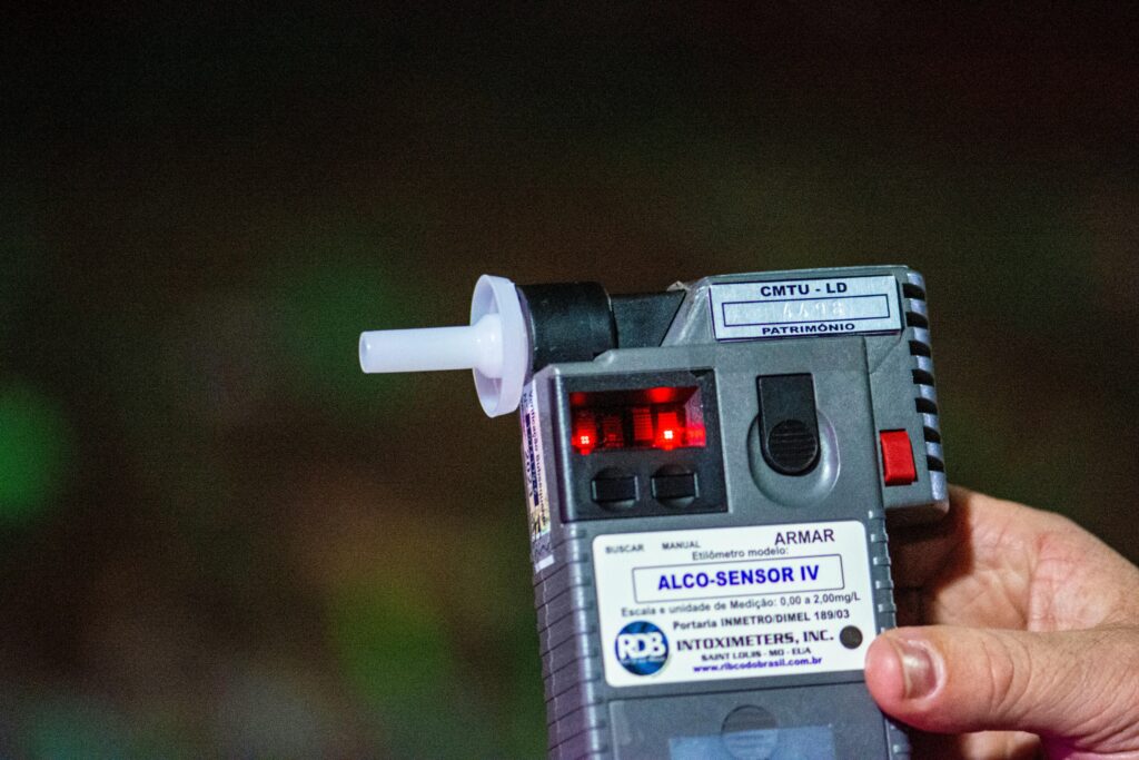 Detailed close-up of Alco-Sensor IV breathalyzer device held by a person outdoors in Londrina, Brazil.